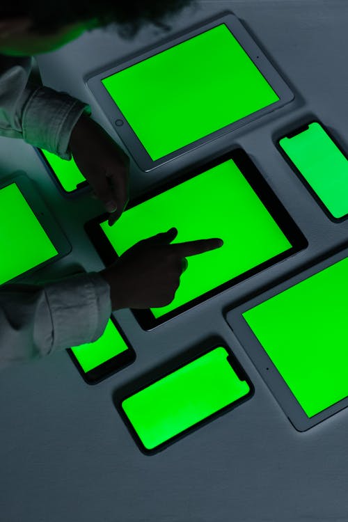 Blackskined boy touching iPad with green screen