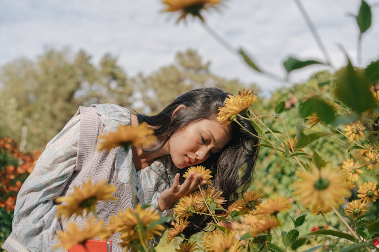 Woman Smelling A Bunch Of Flowers