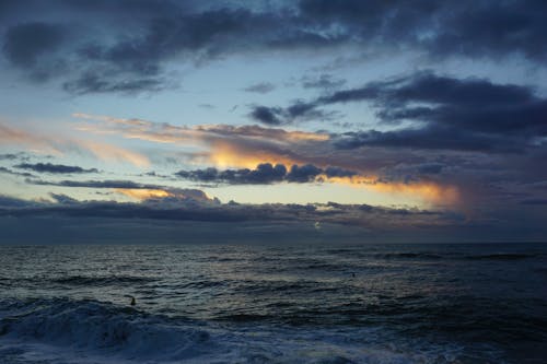 akşam karanlığı, bulutlar, dalgalar içeren Ücretsiz stok fotoğraf