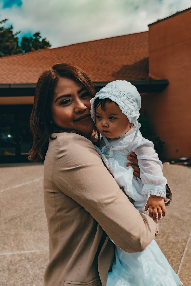 Woman In Brown Blazer Carrying A Baby