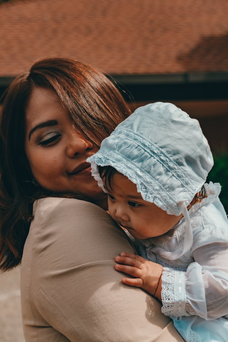 Woman In Beige Shirt Carrying Baby