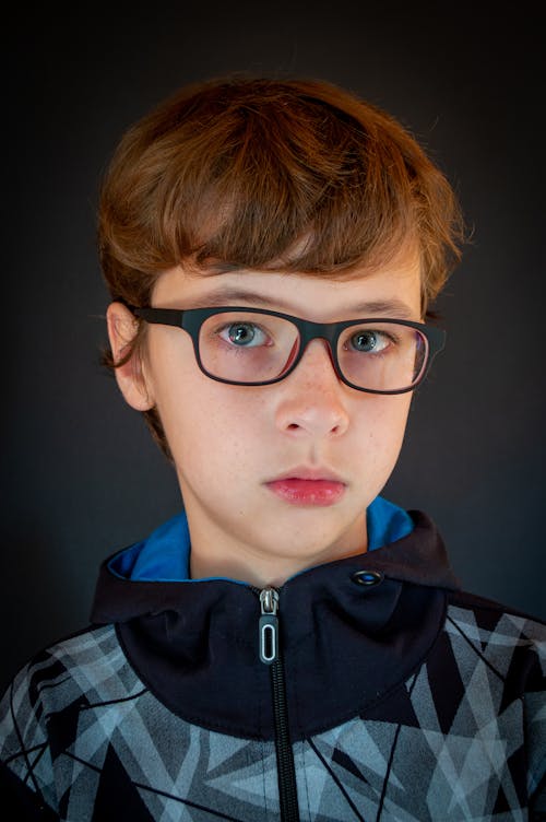 Close-Up Shot of a Boy Wearing Black Eyeglasses