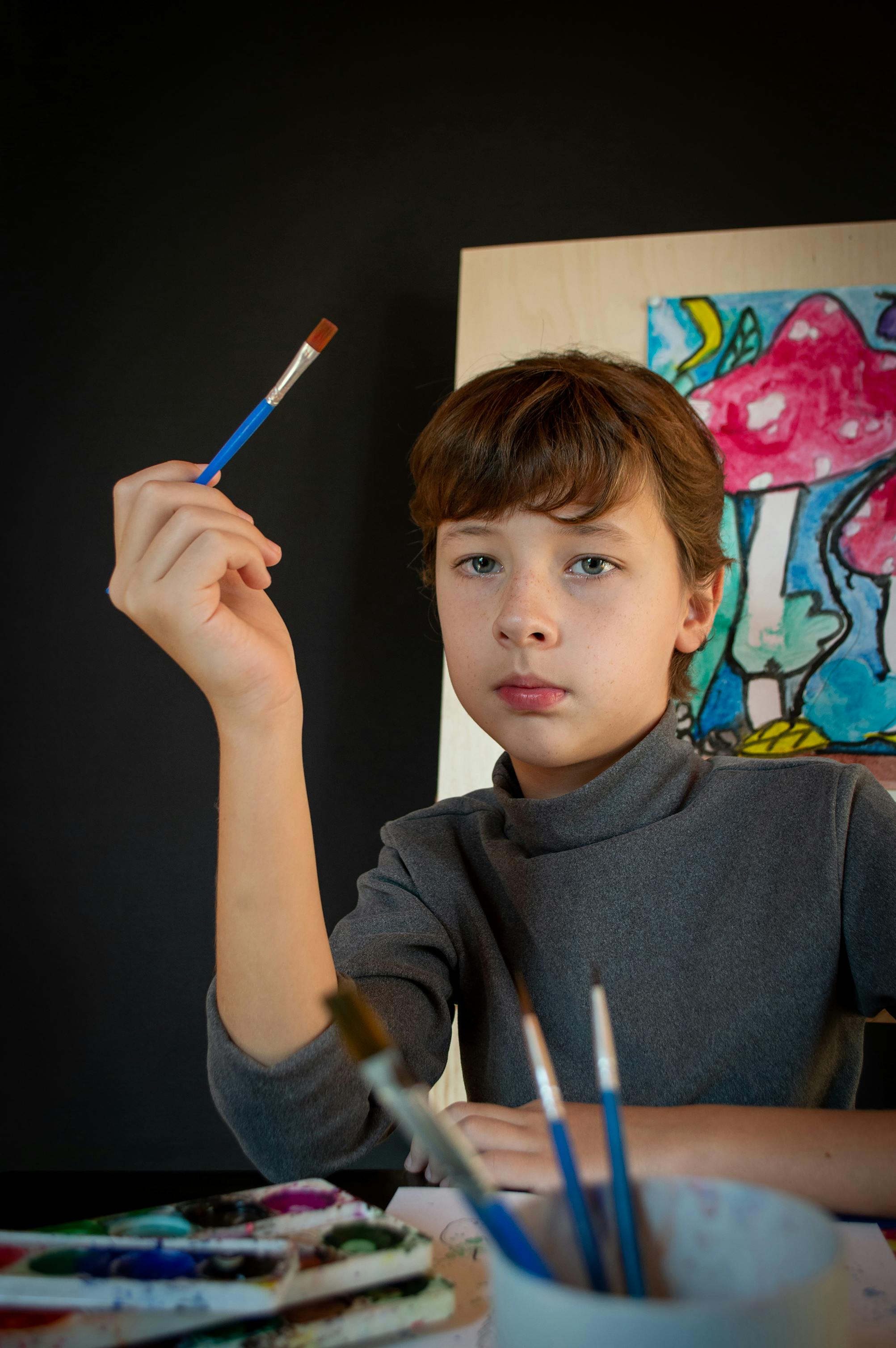 A Cute Little Boy Holding a Holder with Paintbrushes · Free Stock Photo