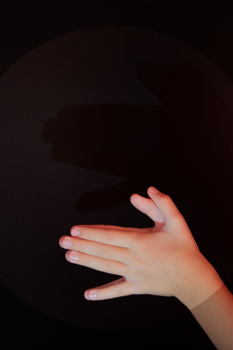 Photo Of Girls Hands Clasped Against Black Background