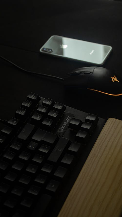 Close-Up Photograph of a Keyboard Near a Computer Mouse
