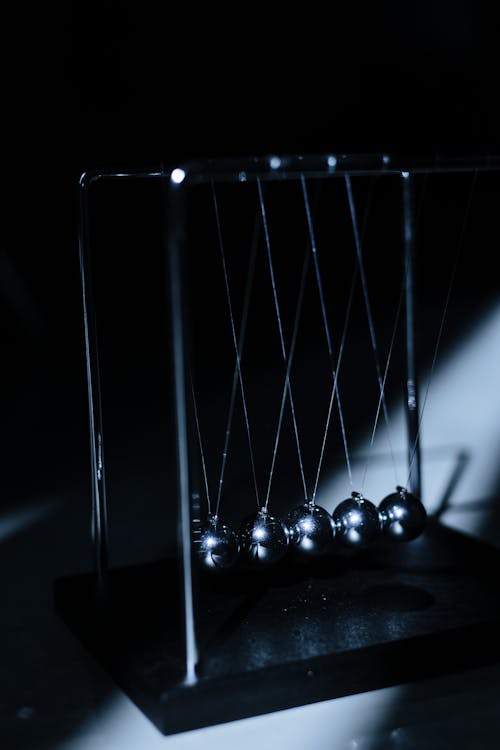 Free Newton s cradle in the darkness and a light streak Stock Photo