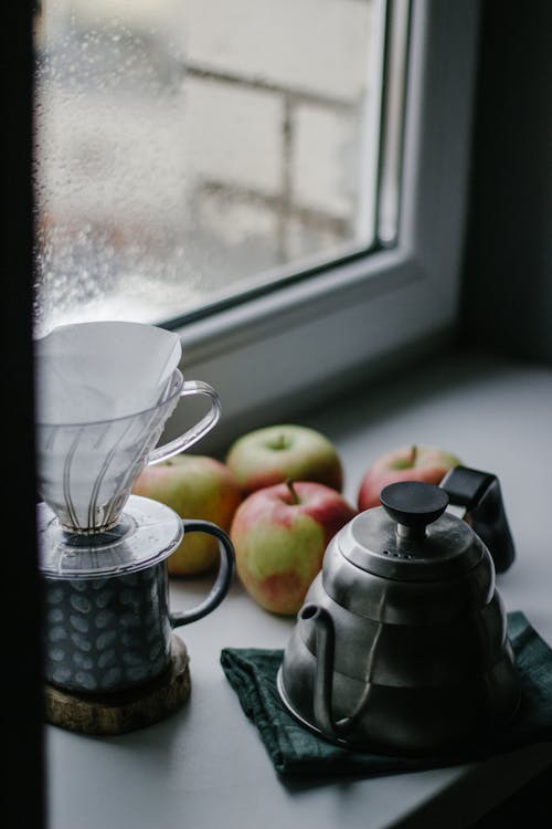 Coffee Maker and Apples Sitting on Windowsill