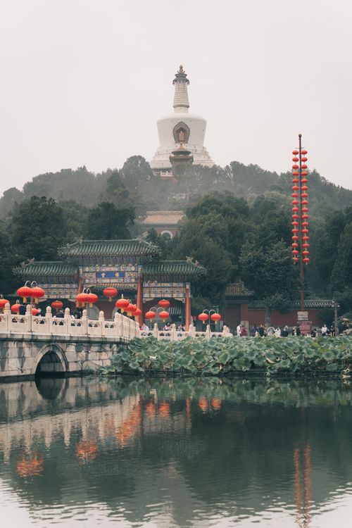 Free Scenic view of Beihai Park's White Pagoda with red lanterns and serene lake reflection. Stock Photo
