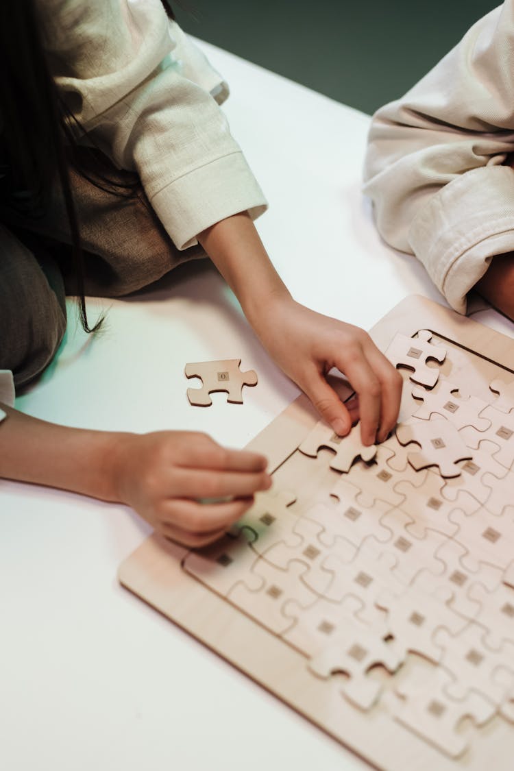 Unrecognizable Hands Doing Jigsaw Puzzle