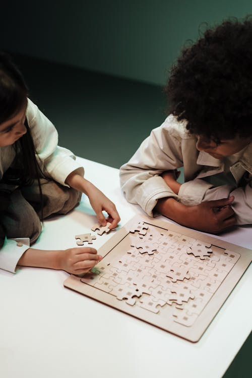 Children adjusting elements of jigsaw puzzles