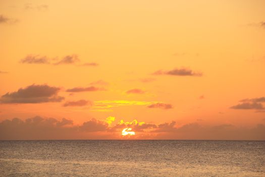 A breathtaking sunset with vivid colors, casting a warm glow over the calm ocean waters in Brazil.