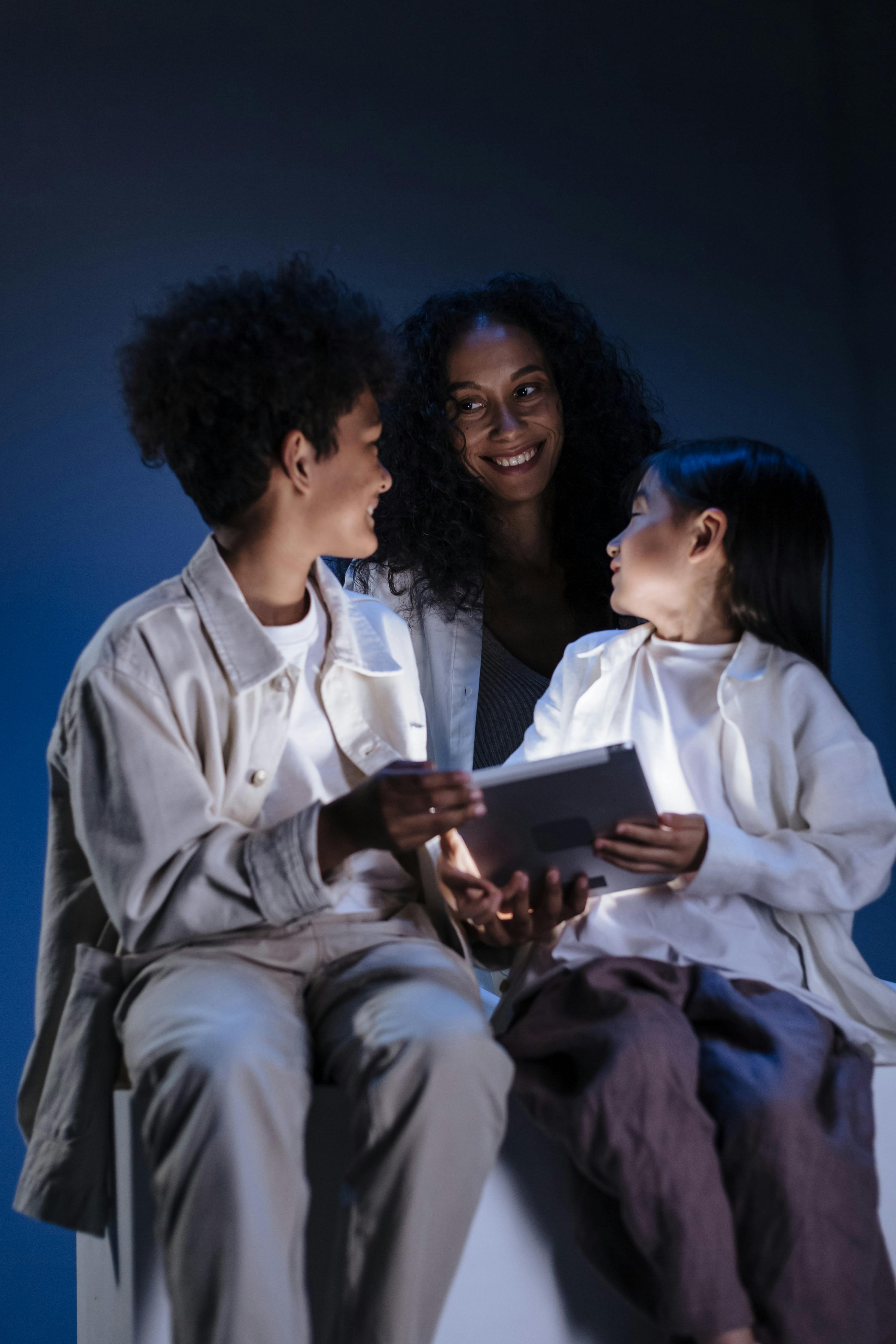 mother smiling to her children holding digital pad