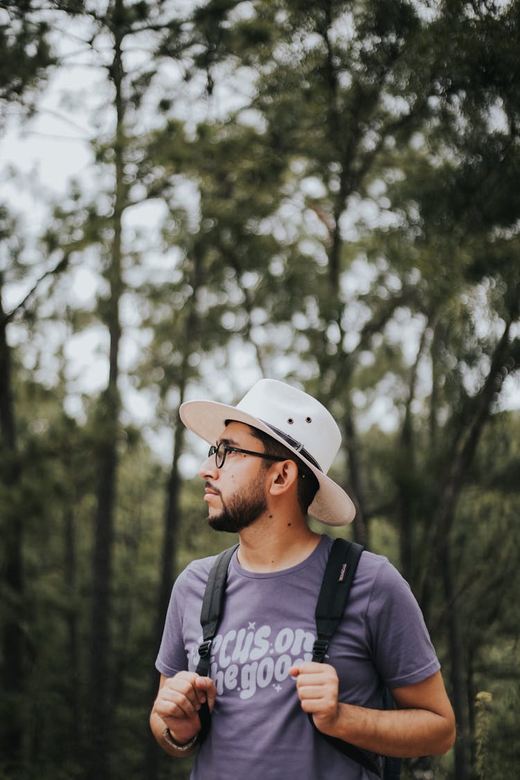 Man In White Hat And Glasses Walking Through Forest