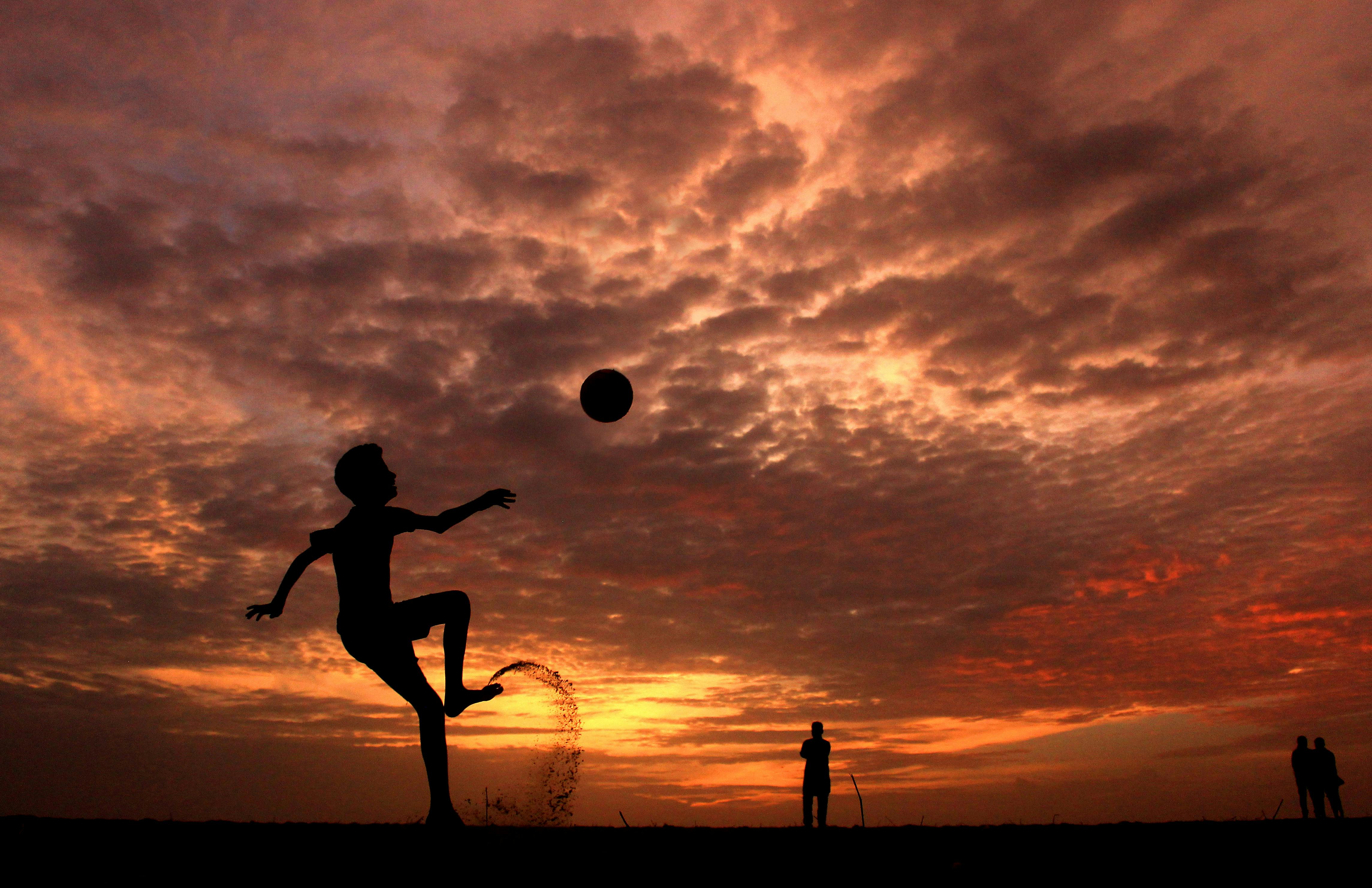 Silhueta de um homem jogando futebol na hora de ouro, por do sol., Foto  Grátis