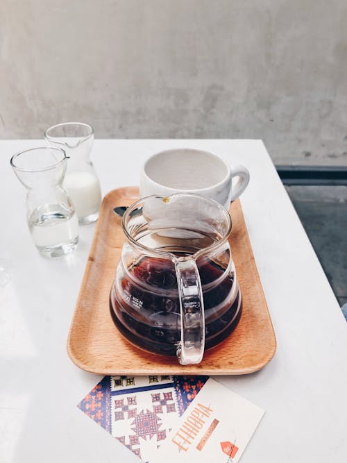 Clear Glass Coffee Pot Near White Mug on Brown Tray