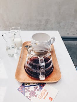 Elegant presentation of brewed coffee, water, and milk on a wooden tray in a Vietnamese cafe setting.