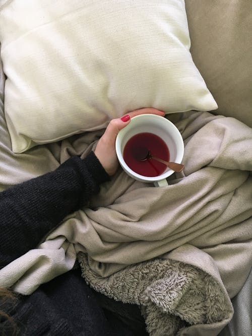 Close-up of Woman in Bed with Cup of Tea