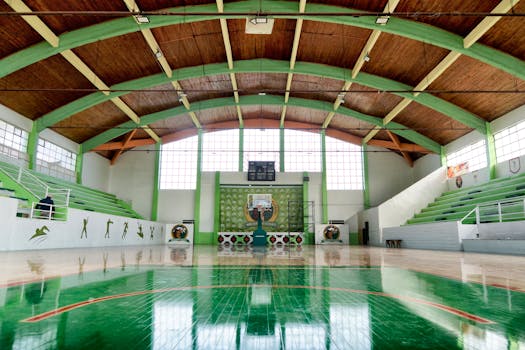 Wide view of an empty indoor basketball court in Lautaro, Chile with green details.