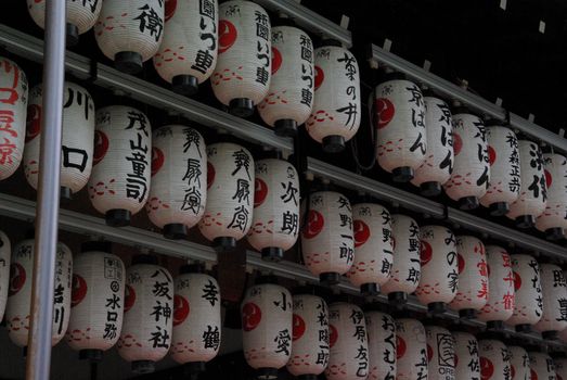Image of traditional hanging lanterns with kanji script at a temple.