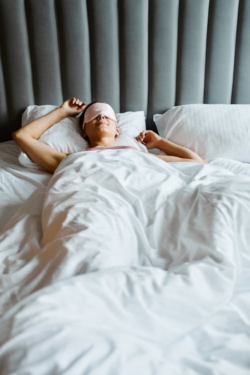 A Woman with Eye Mask Sleeping in the Bed