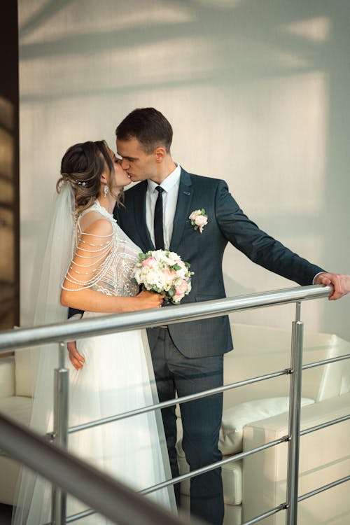 Man in Black Suit Kissing Woman in a Wedding Dress