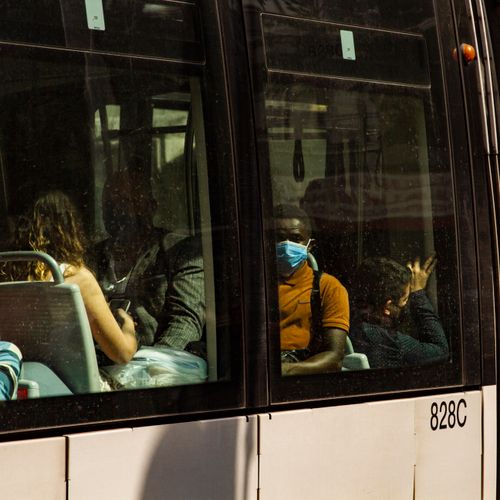 Free Passengers inside a city tram, wearing face masks, reflecting urban life and public transit. Stock Photo