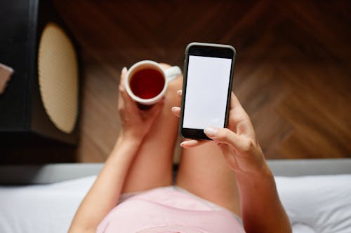 Free Close-Up Shot of a Person Using a Mobile Phone in the Bed Stock Photo