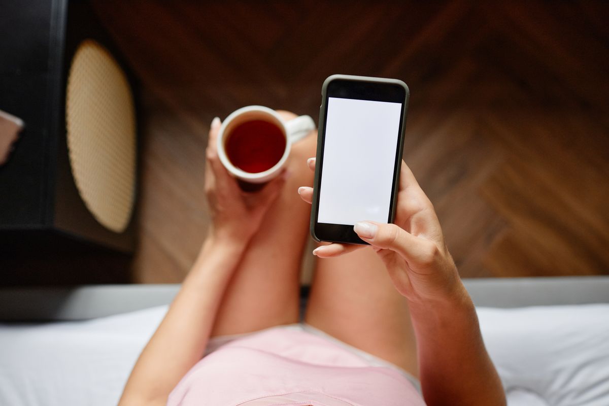 Apprenante suivant une capsule de microlearning sur son mobile pendant une pause café