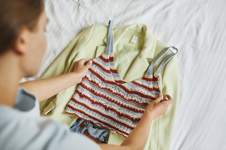 Woman Laying Her Clothes On The Bed 