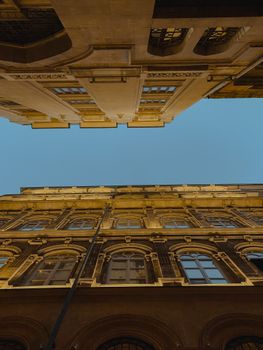 Low-angle shot of historic buildings with intricate facades and clear blue sky.