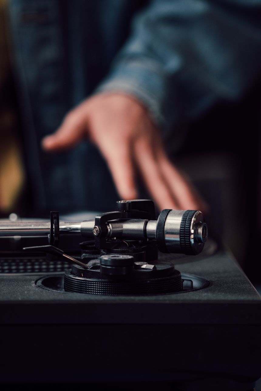 Hand lowering a tonearm onto a turntable platter. Photo by Jan Kopriva on Pexels