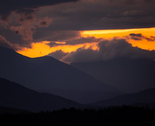 Silhouette of Mountains Under the Cloudy Sky