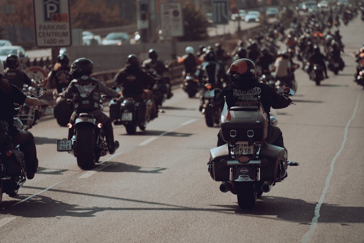 Group Of People Riding Motorcycle On Road