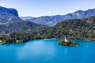 从空中俯瞰，斯洛文尼亚的布莱德湖景色宜人，湖心标志性的岛屿教堂被四周郁郁葱葱的青山环绕