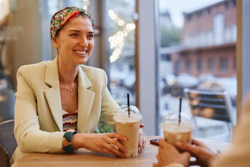 Free Smiling Woman in Beige Blazer Holding Cup of Coffee Stock Photo