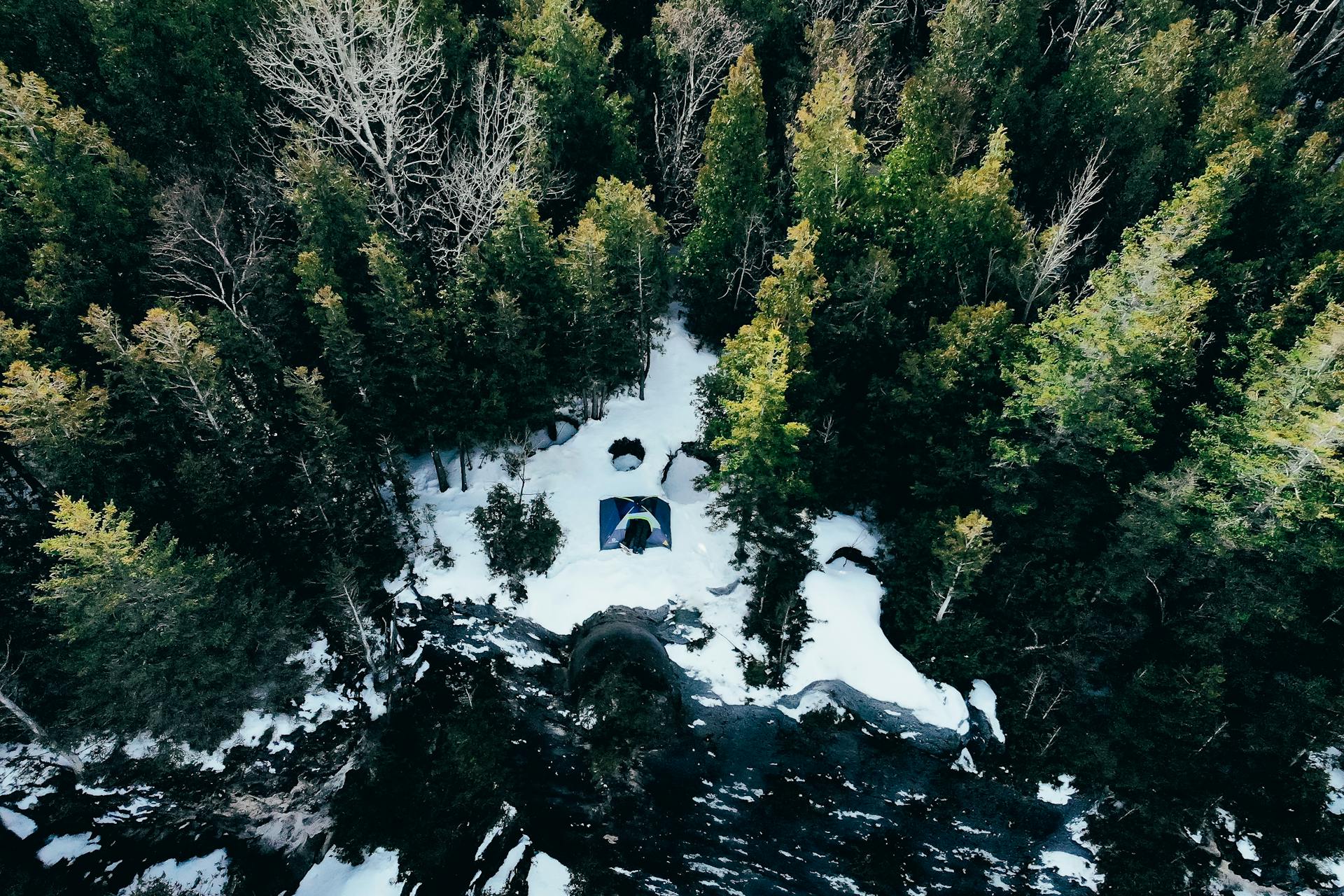 Drone view of a snowy campsite amidst evergreen trees in Lion's Head, Ontario.