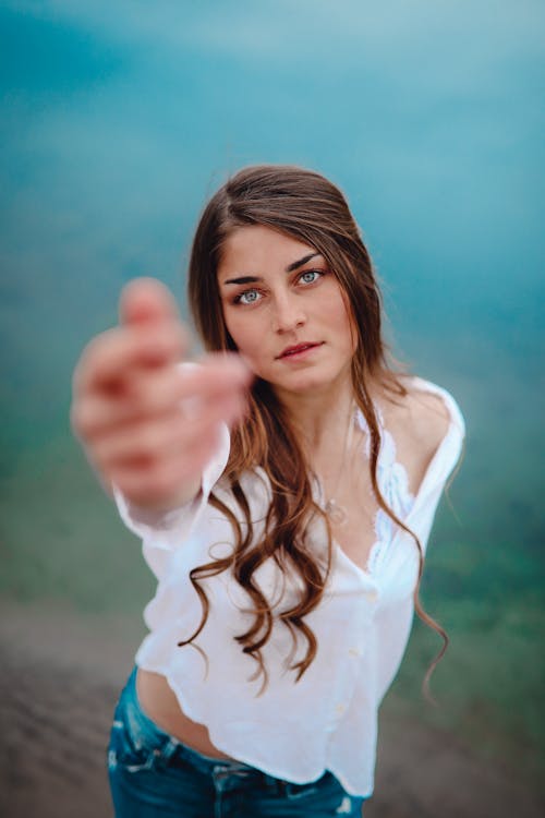 Woman in White Long Sleeves and Denim Jeans 