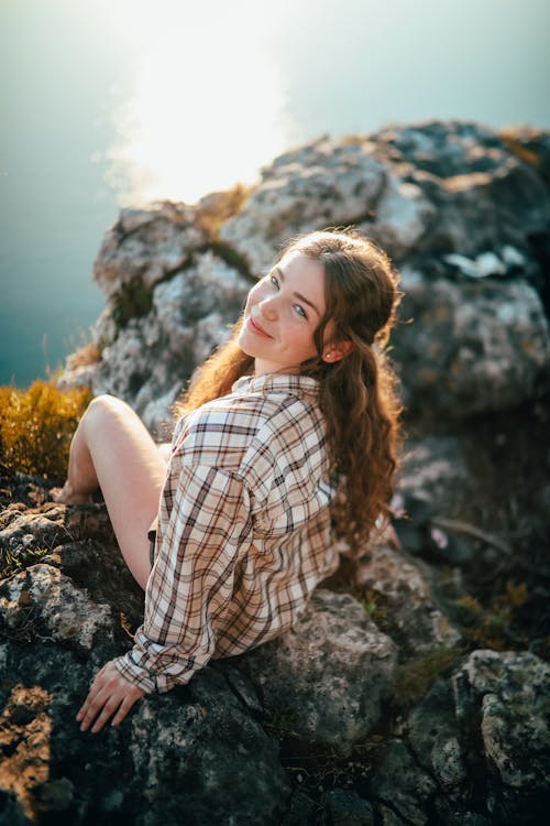 Woman sitting on mountain peak