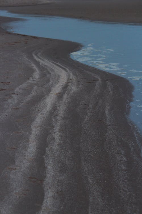 Бесплатное стоковое фото с вертикальный выстрел, вода, песок