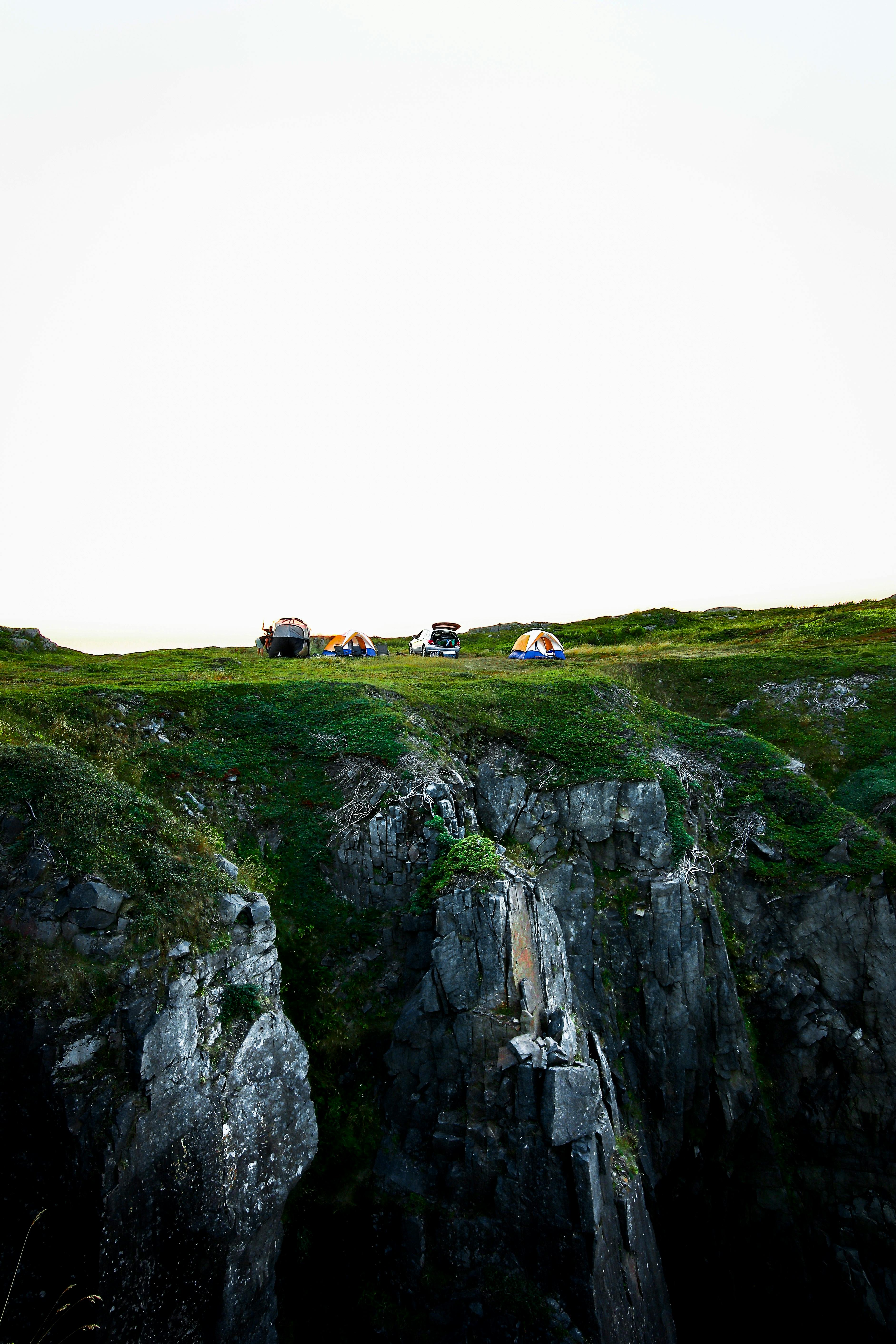 A breathtaking cliffside campsite offering a stunning view amid untouched nature, perfect for outdoor adventures.