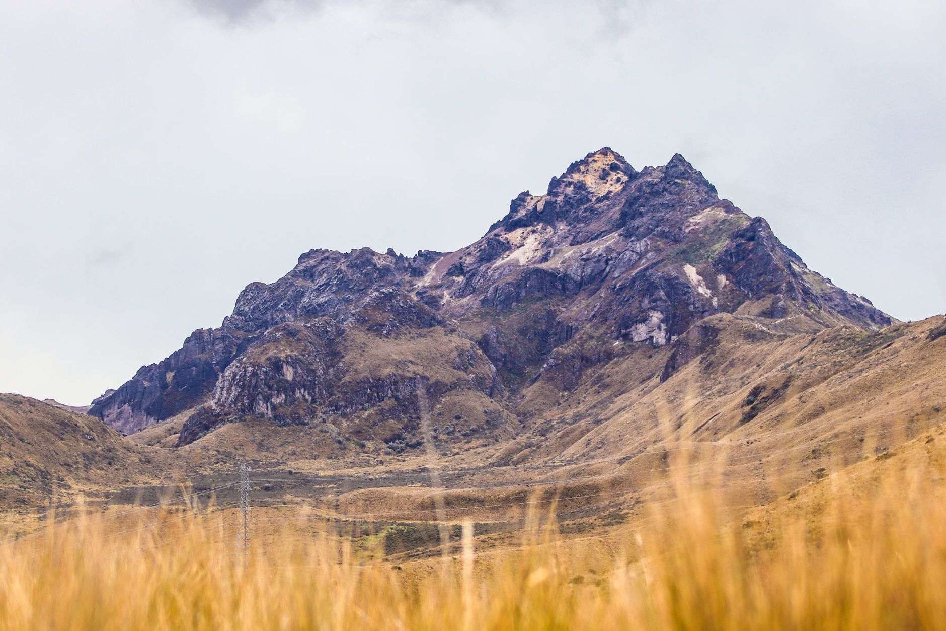 Breathtaking view of Andes mountains with rugged peaks and grassy plains in Pichincha, Ecuador.
