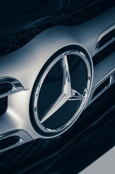 High angle close-up of a luxury car emblem on a sleek black grille showcasing design excellence. 9792974