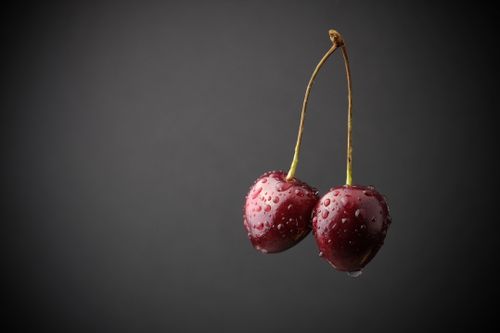 Free Close-up of fresh cherries with water droplets on a black background, showcasing freshness and vibrancy. Stock Photo