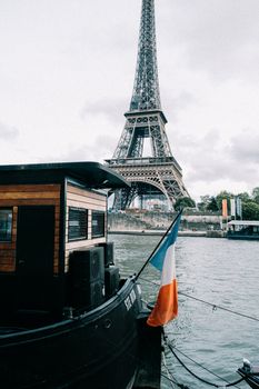 A boat with a French flag docked near the Eiffel Tower in Paris.