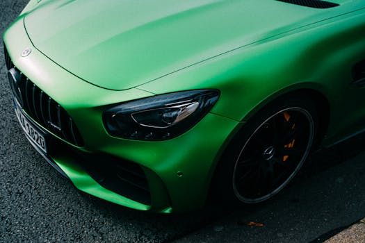 Close-up of a green luxury Mercedes sports car with a focus on the headlight.