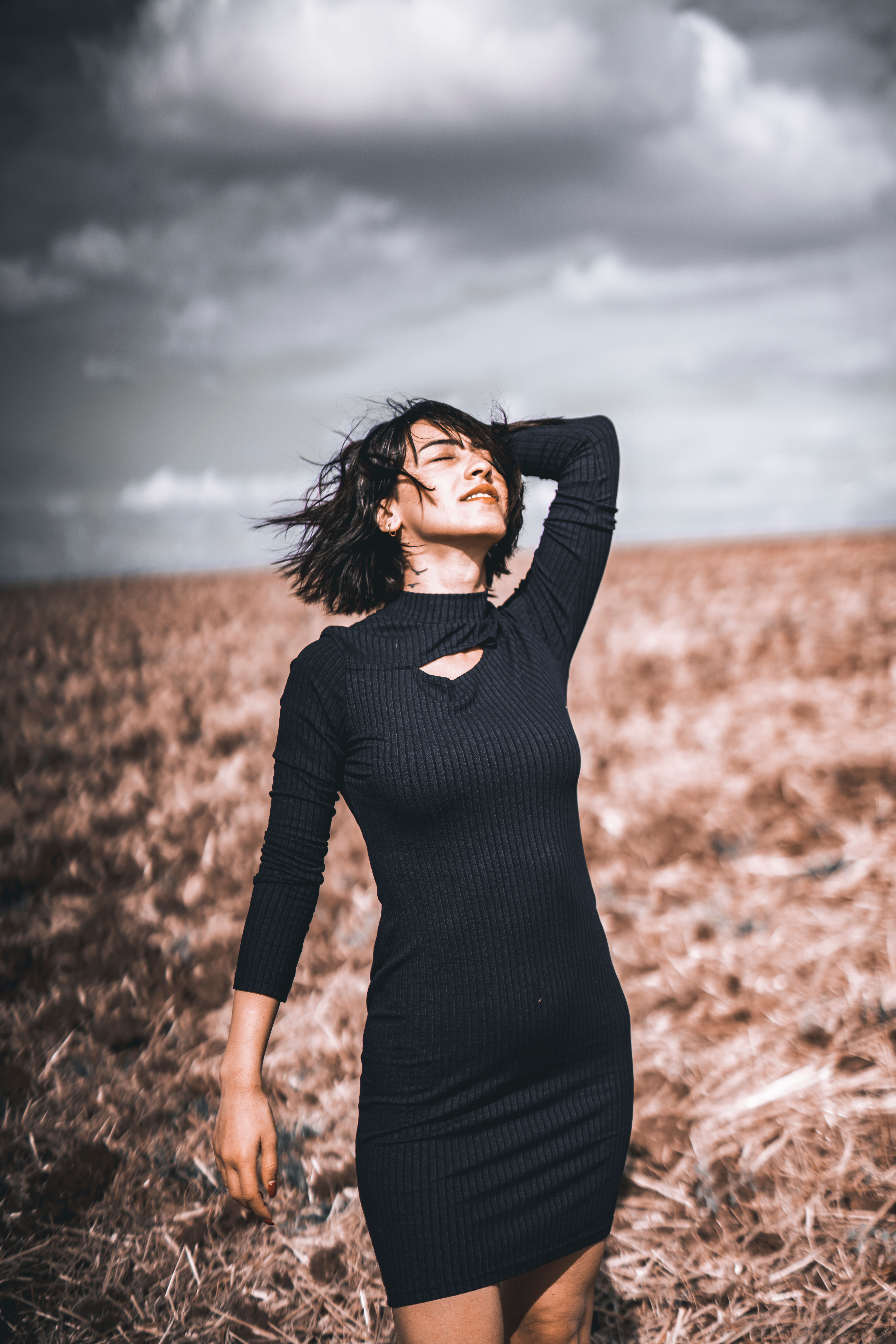 Back View of a Woman in a Black Dress Standing on a Road · Free Stock Photo