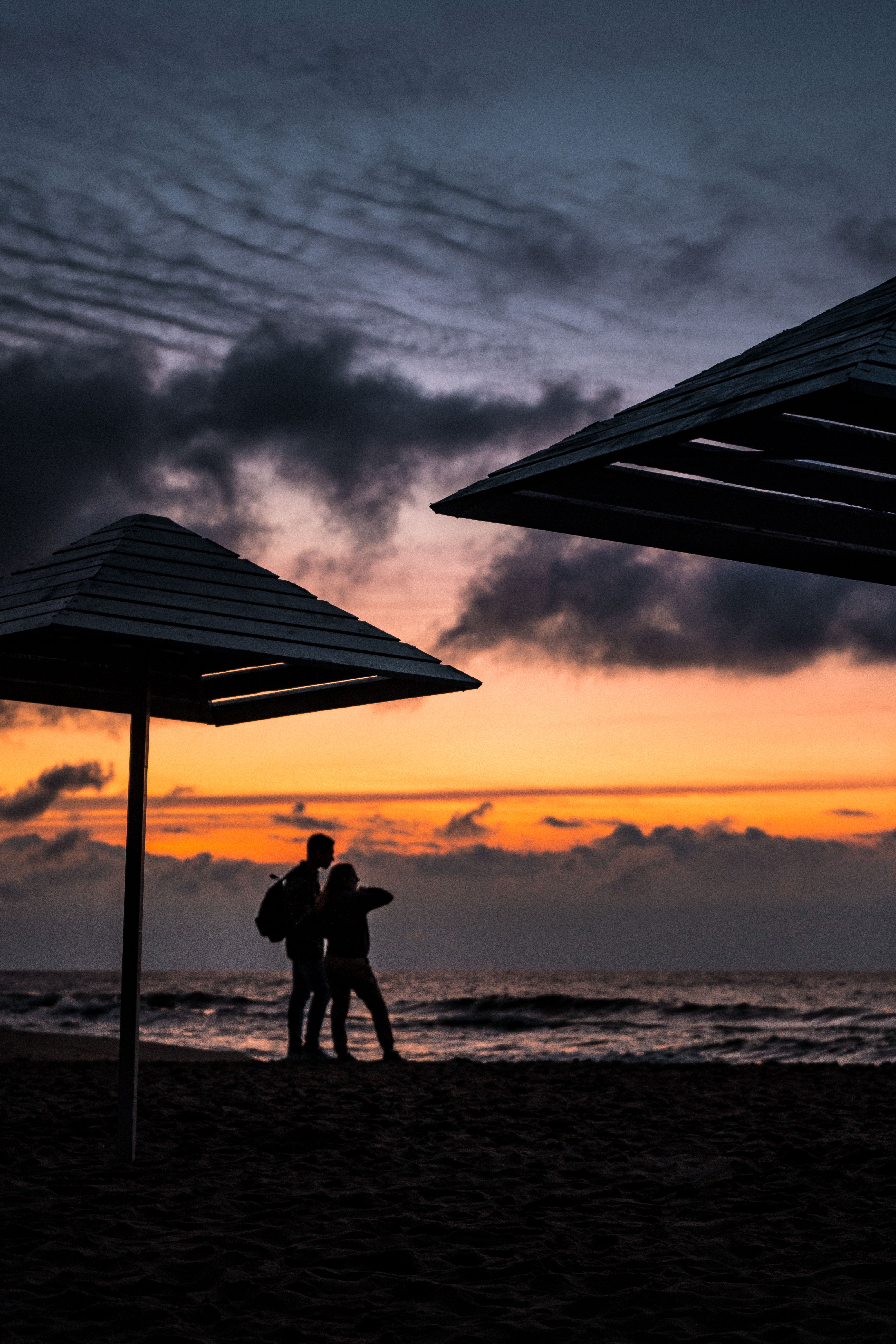 Silhouette of Couple Standing on Beach during Sunset · Free Stock Photo