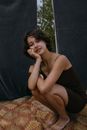 Woman in Black Tank Top Sitting on Brown Fur Textile