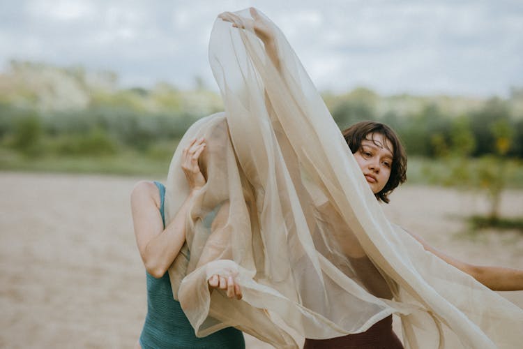 Two Female Models Posing With Sheer Cloth On Beach