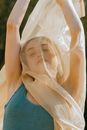 Woman with arms raised covered by shawl